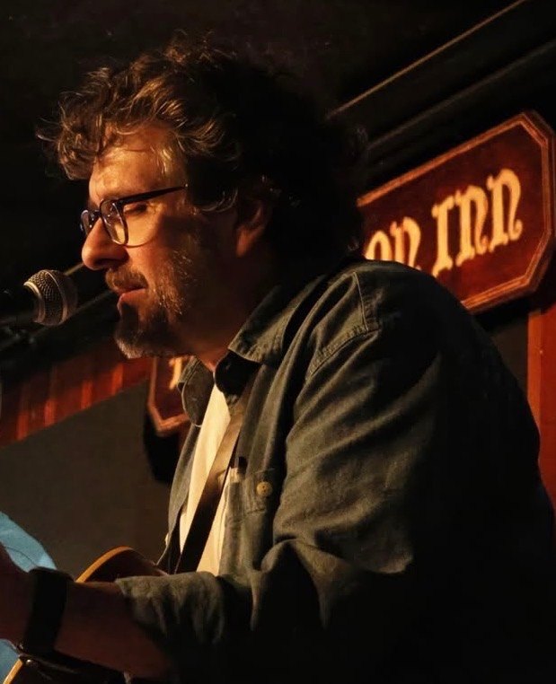 Jay Knowles performing at a club, warm light